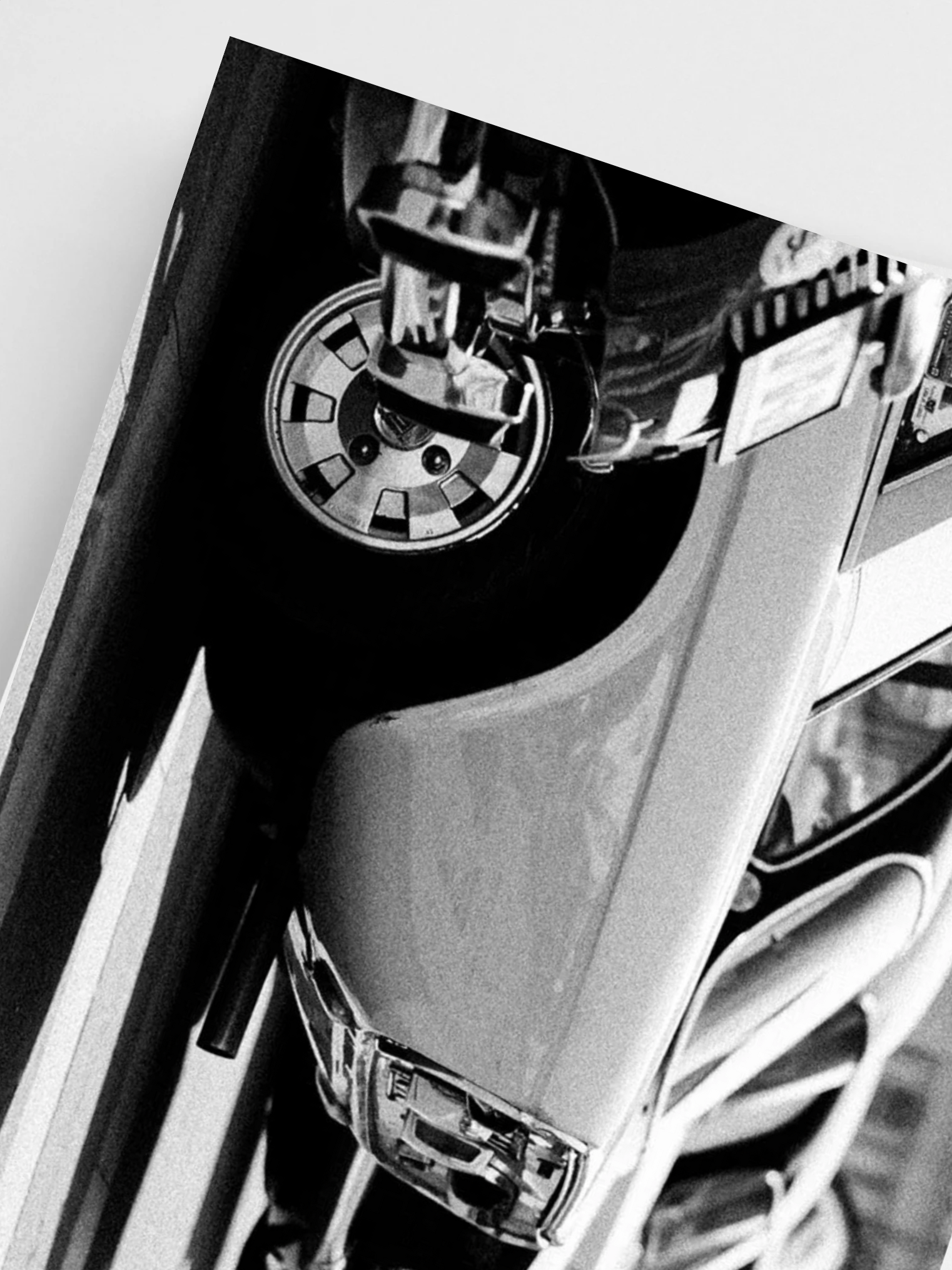 Close-up of a Cars headlight and front wheel on a white background