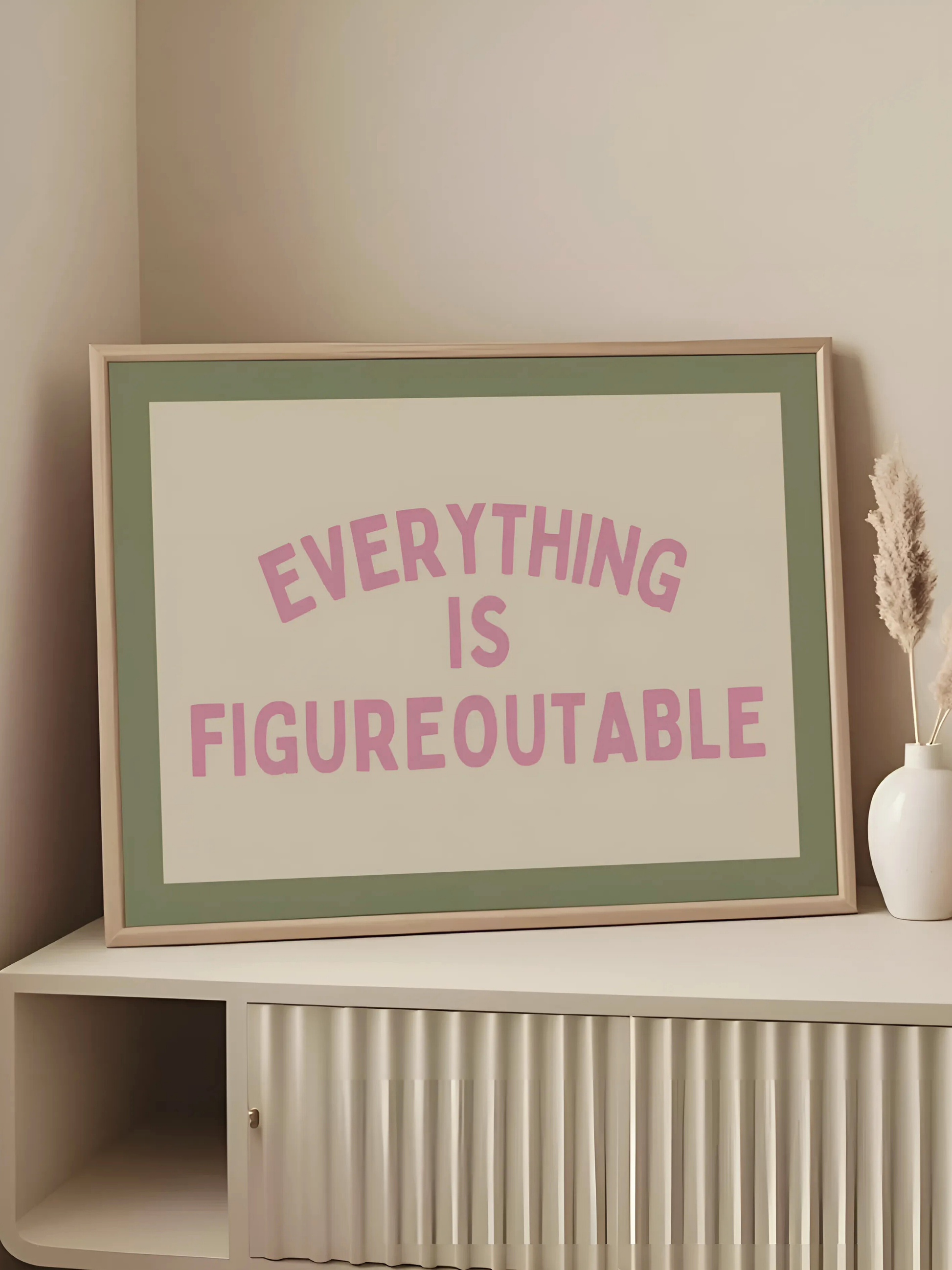 Framed poster with 'Everything is Figureoutable' text on a shelf.
