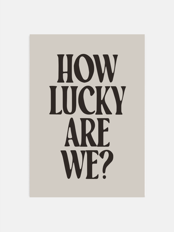 How Lucky Are We black typography poster on a bedroom wall with retro decor.