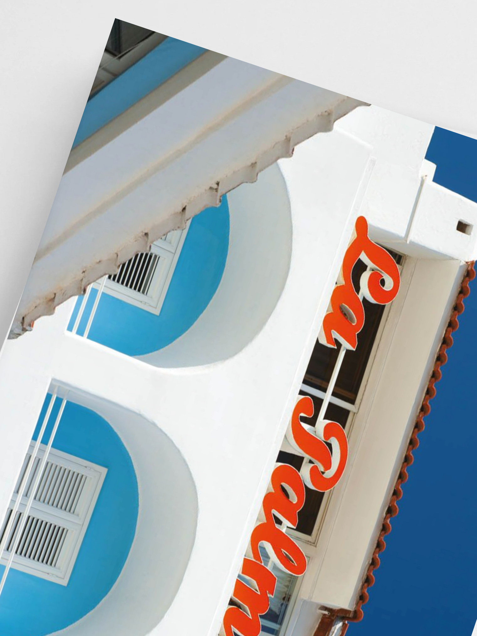 Close-up of a store sign with 'La Palma' in orange letters against a blue sky.