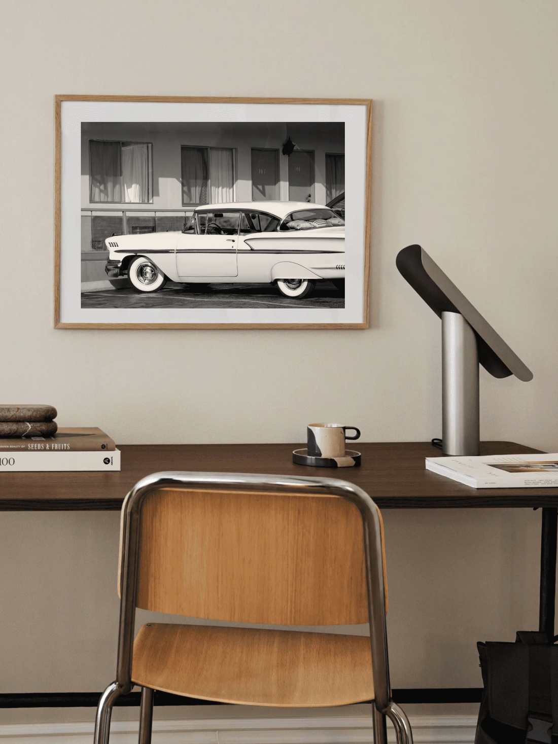 Black and white photo of a vintage car in front of a motel