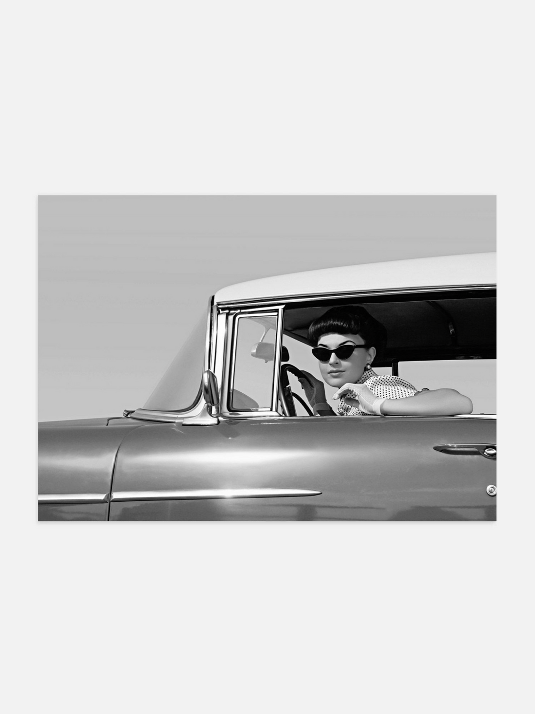 Woman in sunglasses driving a vintage car