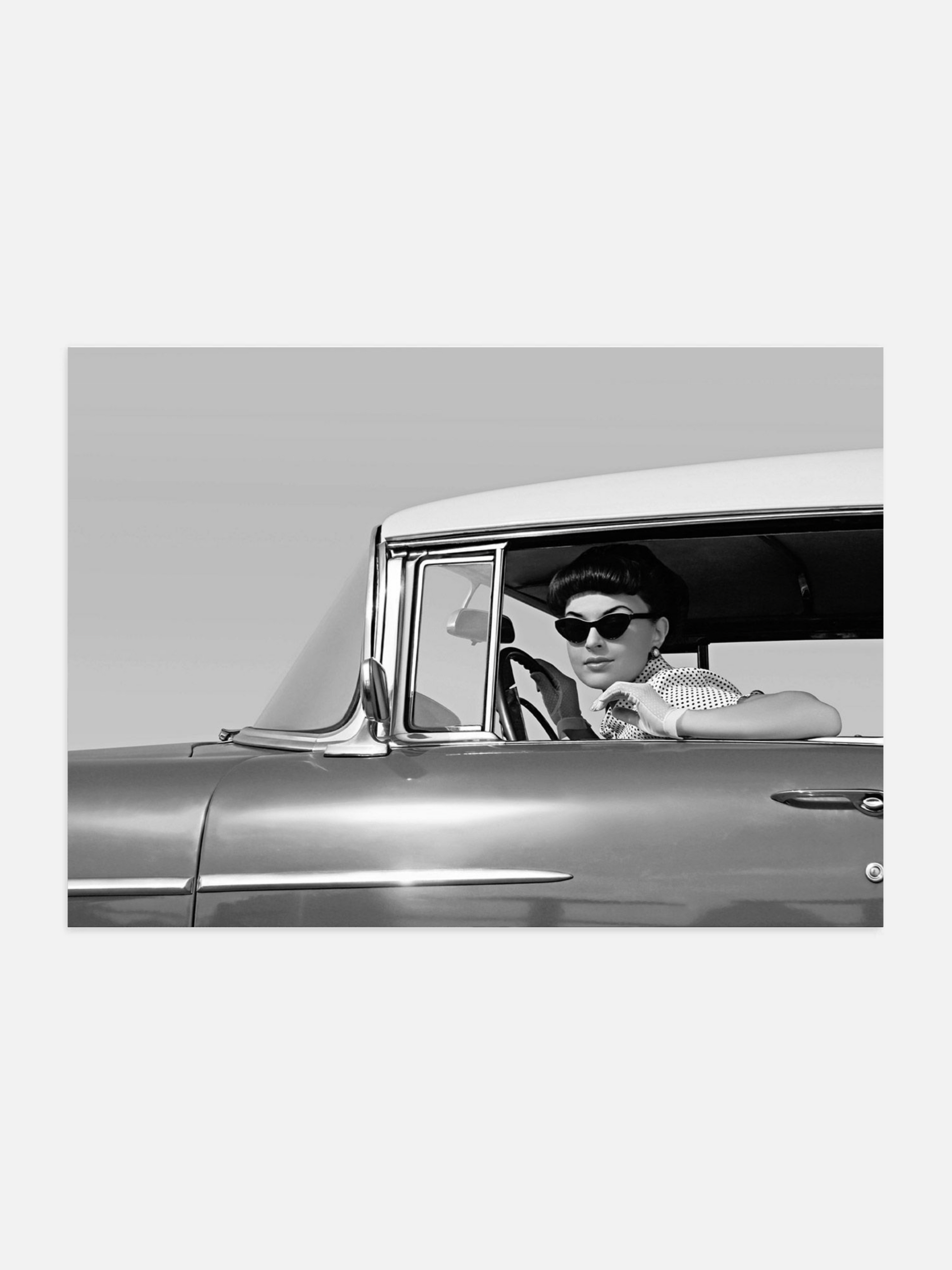 Woman in sunglasses driving a vintage car