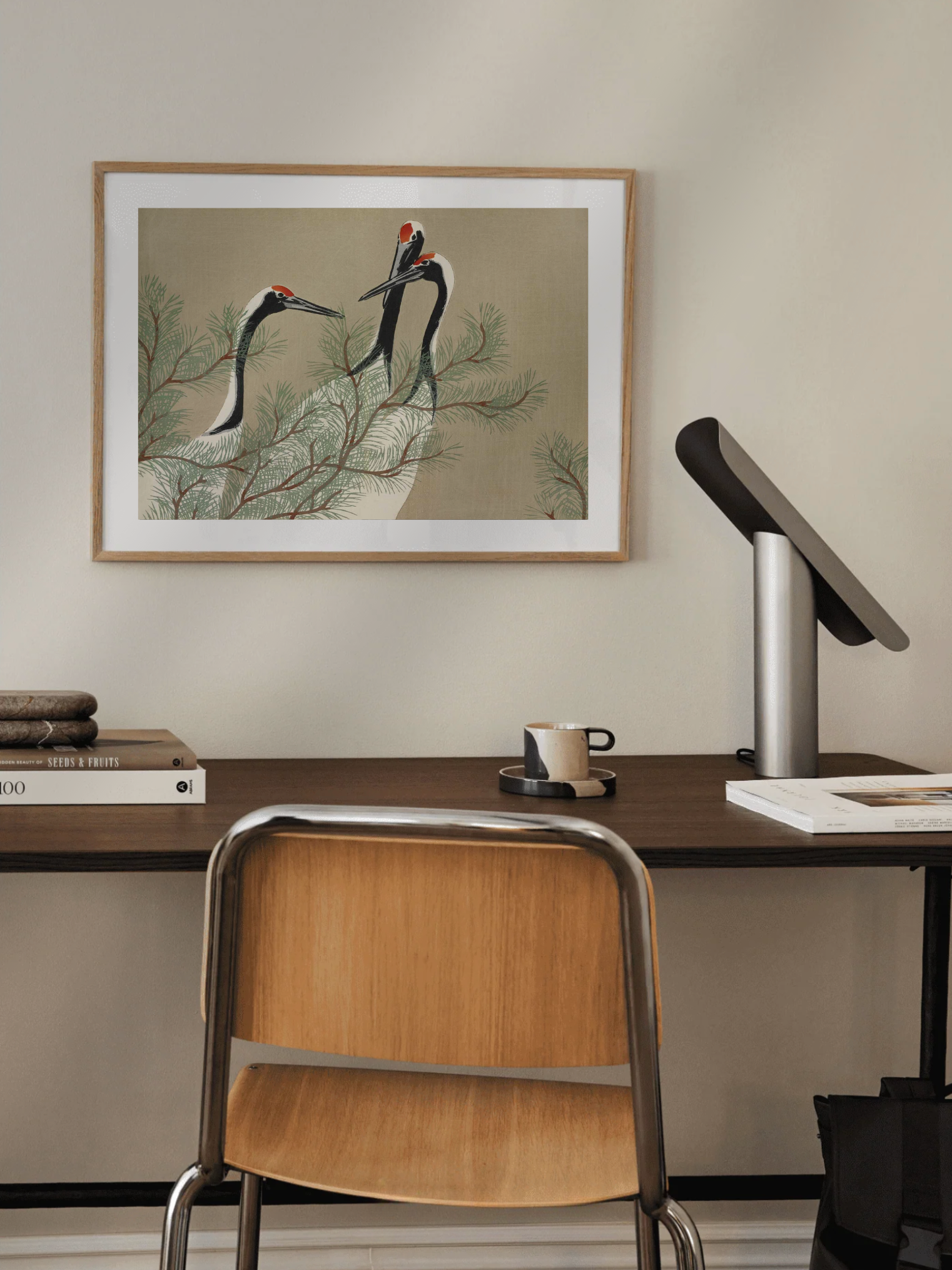 Desk setup with a framed artwork of Elegant crane artwork in neutral tones