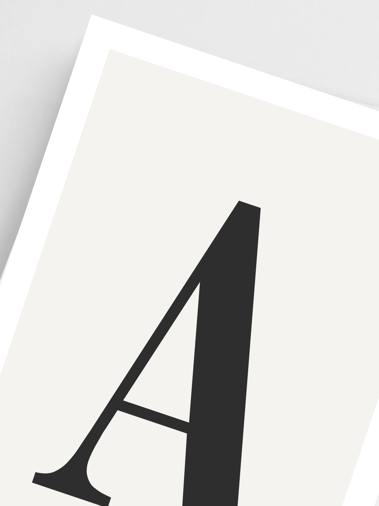 Close-up of custom letter poster – soft beige texture and serif font on gray background