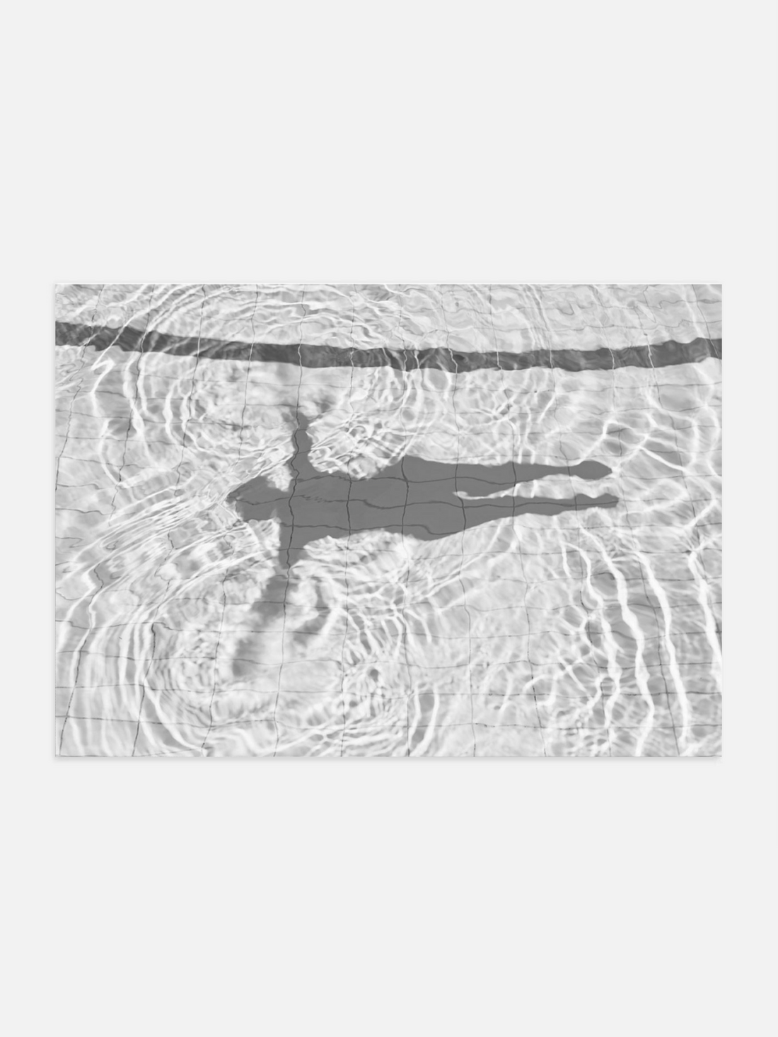 Shadow of floating figure in a swimming pool