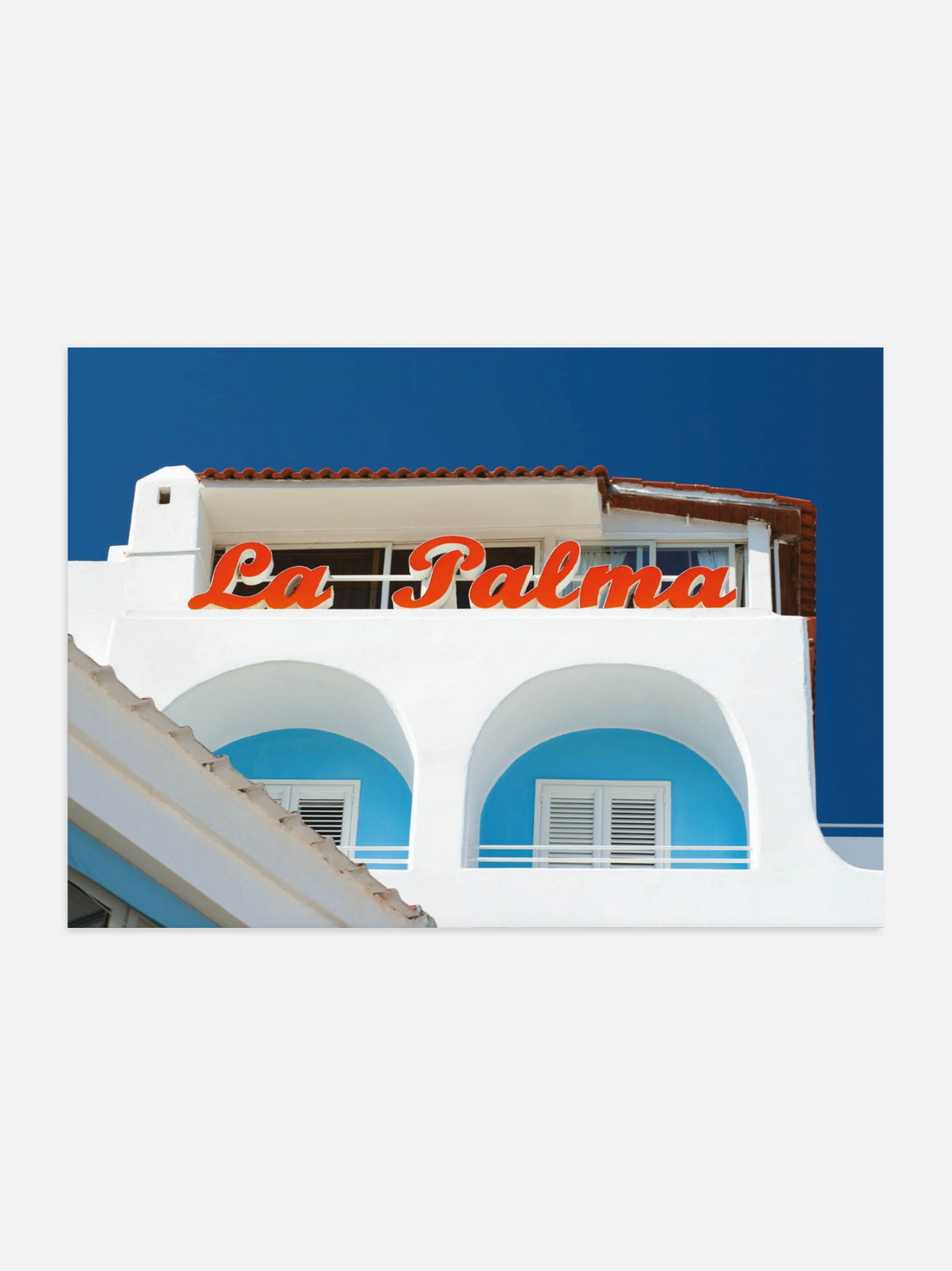 Building facade with 'La Palma' sign against a blue sky