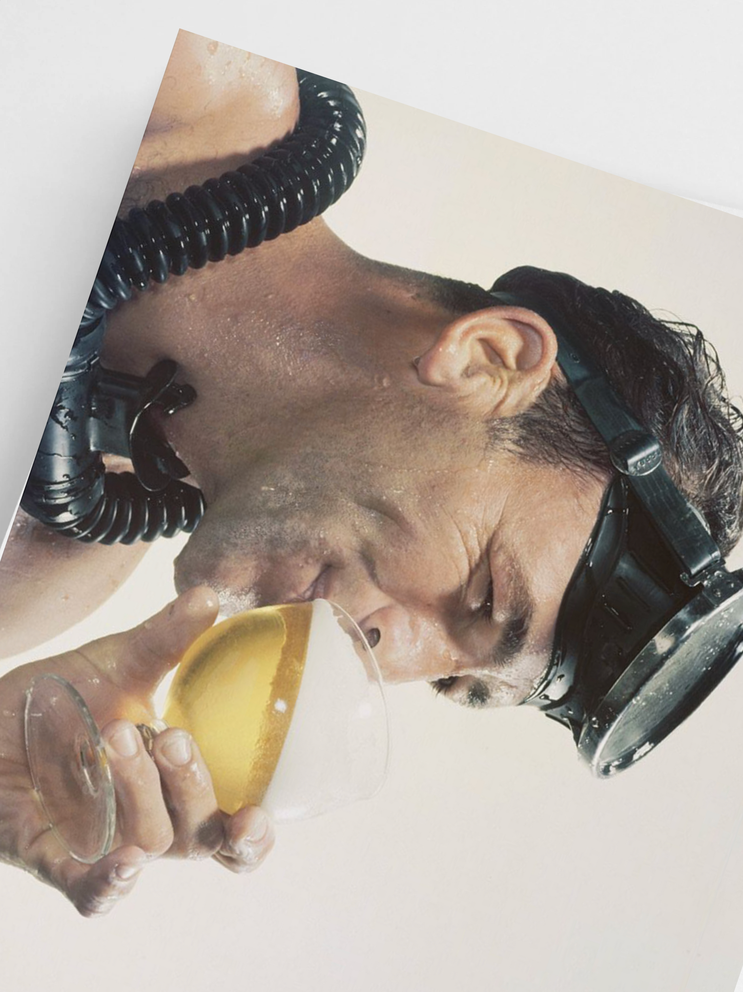 Person wearing a diving mask holding a glass, with a white background