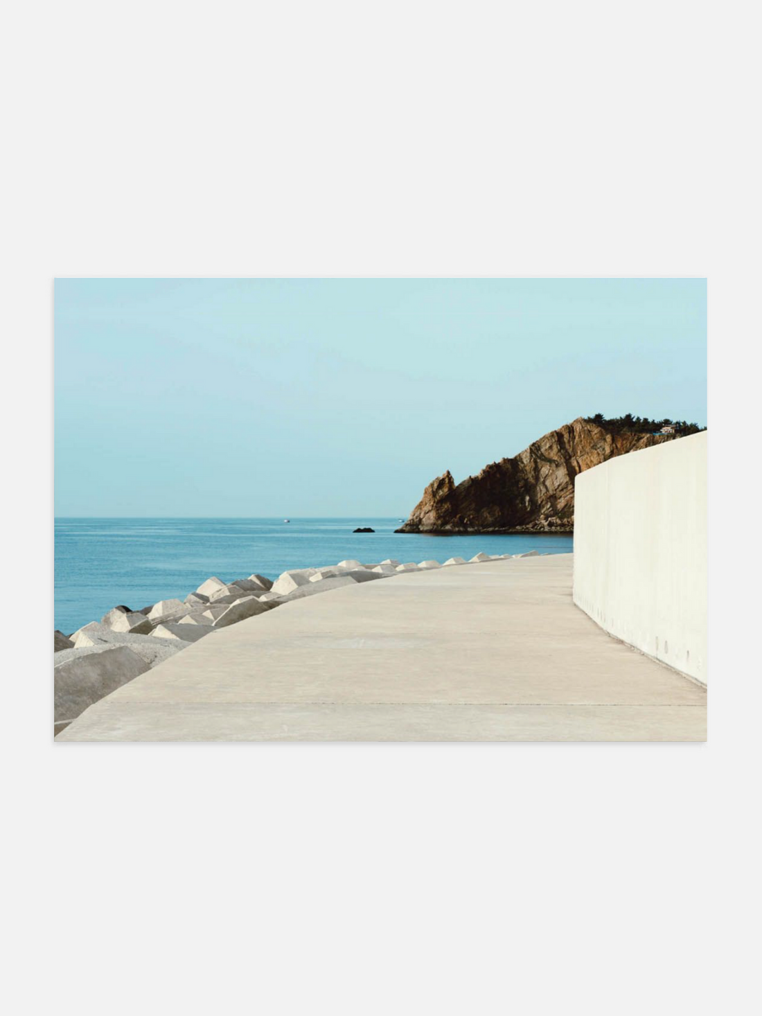 White building with a view of the ocean and cliffs.