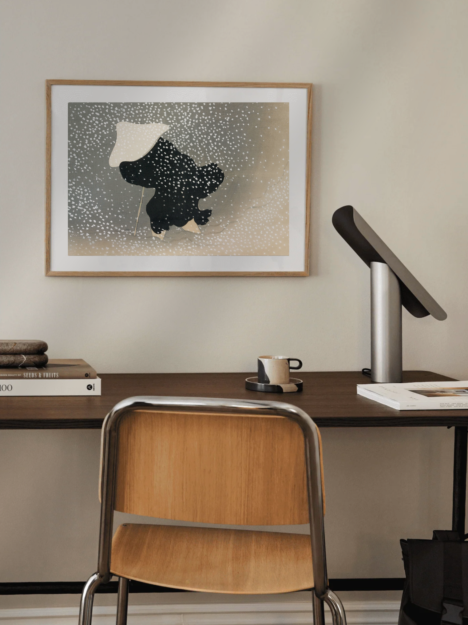 Framed artwork of a Vintage Japanese snow artwork in soft tones on a wall above a desk with a chair.
